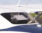 Starlink Mini Kit attaches to an aircraft windshield via a suction cup mount. 