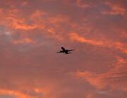 A generic airplane flying into the sunset.