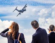 People looking at an airplane in the sky