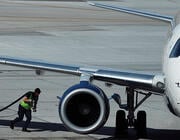 worker carrying refueling hose to aircraft