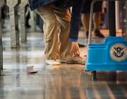man taking shoes off at TSA checkpoint