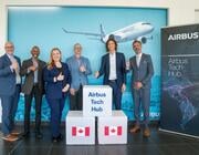 Airbus employees in front of signs for the new tech hub in Canada