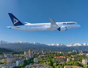 Boeing Air Astana aircraft flying over snowy mountains