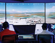 Two people at computers in air traffic control tower simulator