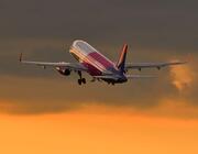 Wizz Air aircraft inflight with a sunset