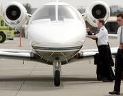 two pilots walking by private jet