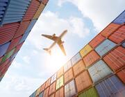 aircraft flying above shipping containers