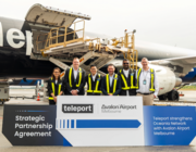 airport staff with teleport–avalon partnership sign in front of cargo plane