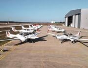 two rows of small white training aircraft on airport apron