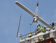 workers on tower as surface movement radar arrives by crane