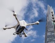 delivery drone in sky next to skyscraper