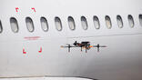 Drone hovering by airliner windows